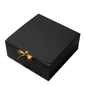 A square-shaped black gift box with a simple, matte finish, embellished with a small golden ribbon bow at the front.