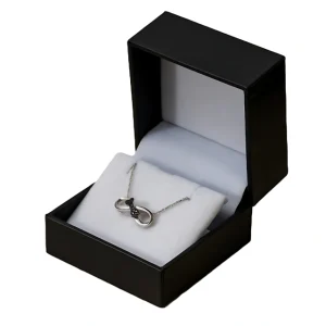 An open black jewelry box with a white interior cushion, holding a silver infinity-styled necklace.