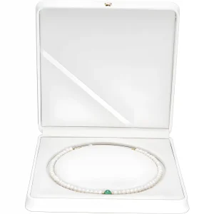 یک رشته گردنبند مروارید سفید ظریف با لهجه سنگ جواهر سبز، که در جعبه جواهرات سفید قرار گرفته است.