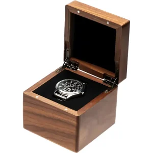 A sleek wristwatch with a black dial and multiple sub-dials is nestled in a luxurious wooden box with a dark velvet interior.