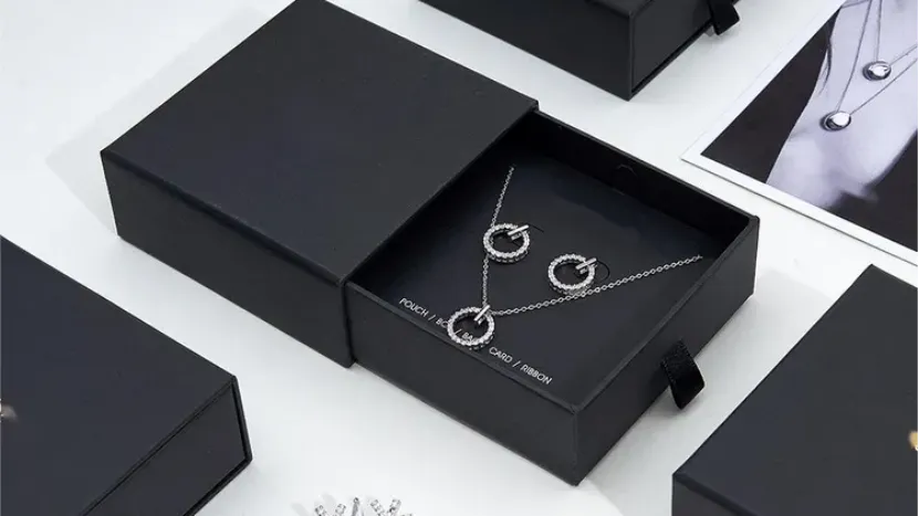 black jewelry boxes displaying silver necklace and earrings