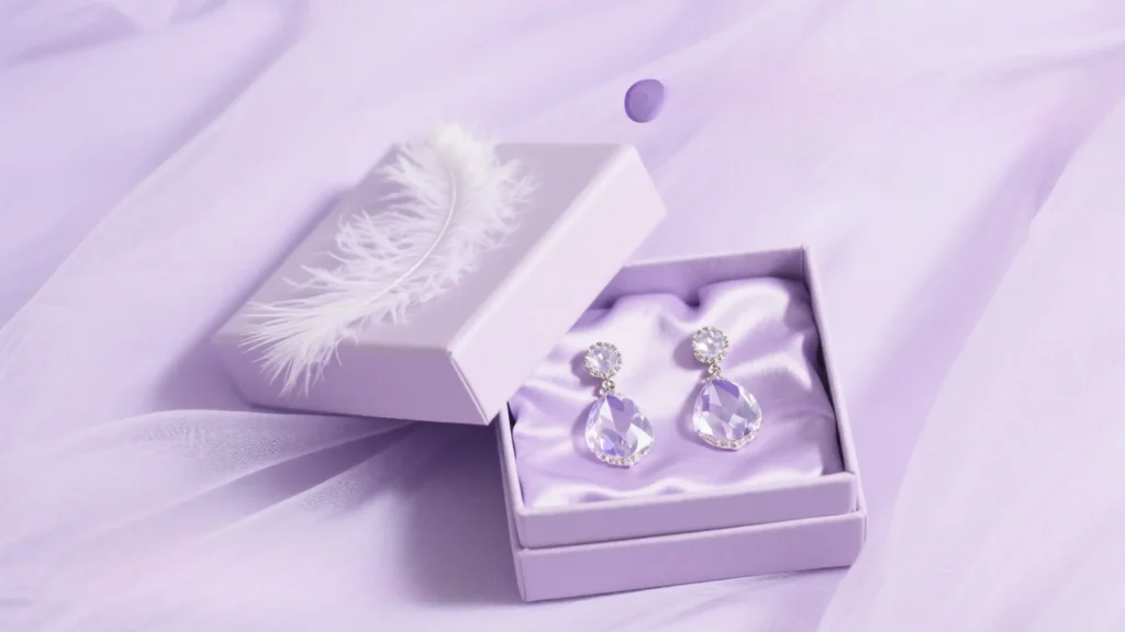 purple jewelry box with earrings on lilac fabric