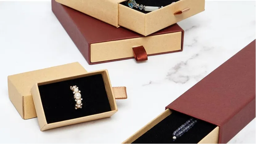 stack of multi colored jewelry boxes with gold bracelet