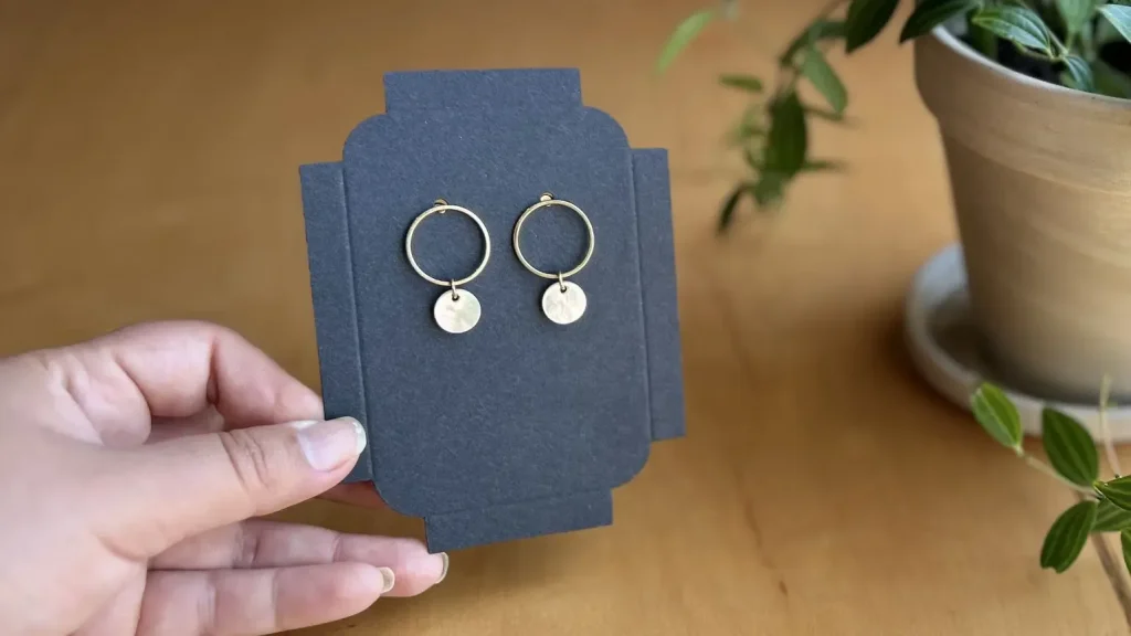 hand holding blue jewelry box with earrings