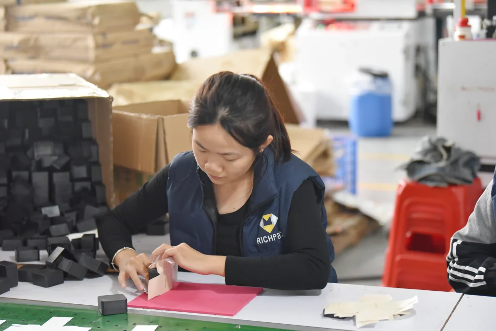 Richpack jewelry box factory worker folding components for box assembly