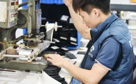 Jewelry box factory technician using hot stamping machine to add branding details to box components