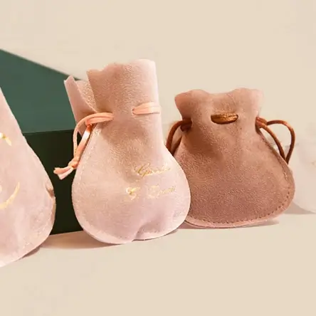 Elegant blush pink & taupe velvet drawstring jewelry pouches with gold foil detailing, perfect for delicate jewelry storage.