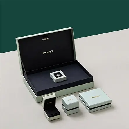 Luxury mint green jewelry box set with black interior, including large gift box, ring box, and branded storage boxes.